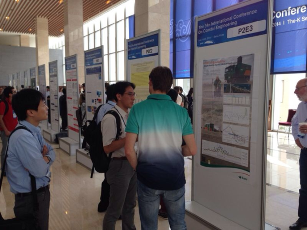 Participants of ICCE 2014 look at the Ecobeach poster